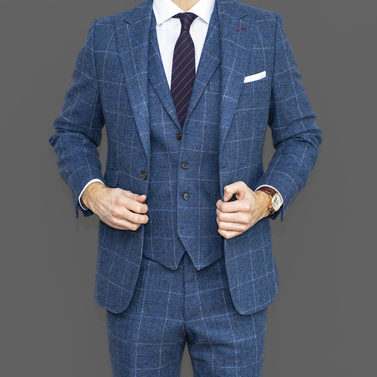 Master tailor taking precise measurements on a bespoke suit in an atelier studio